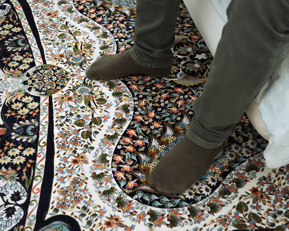 Amor standing on a decorative patterened carpet wearing green carky socks