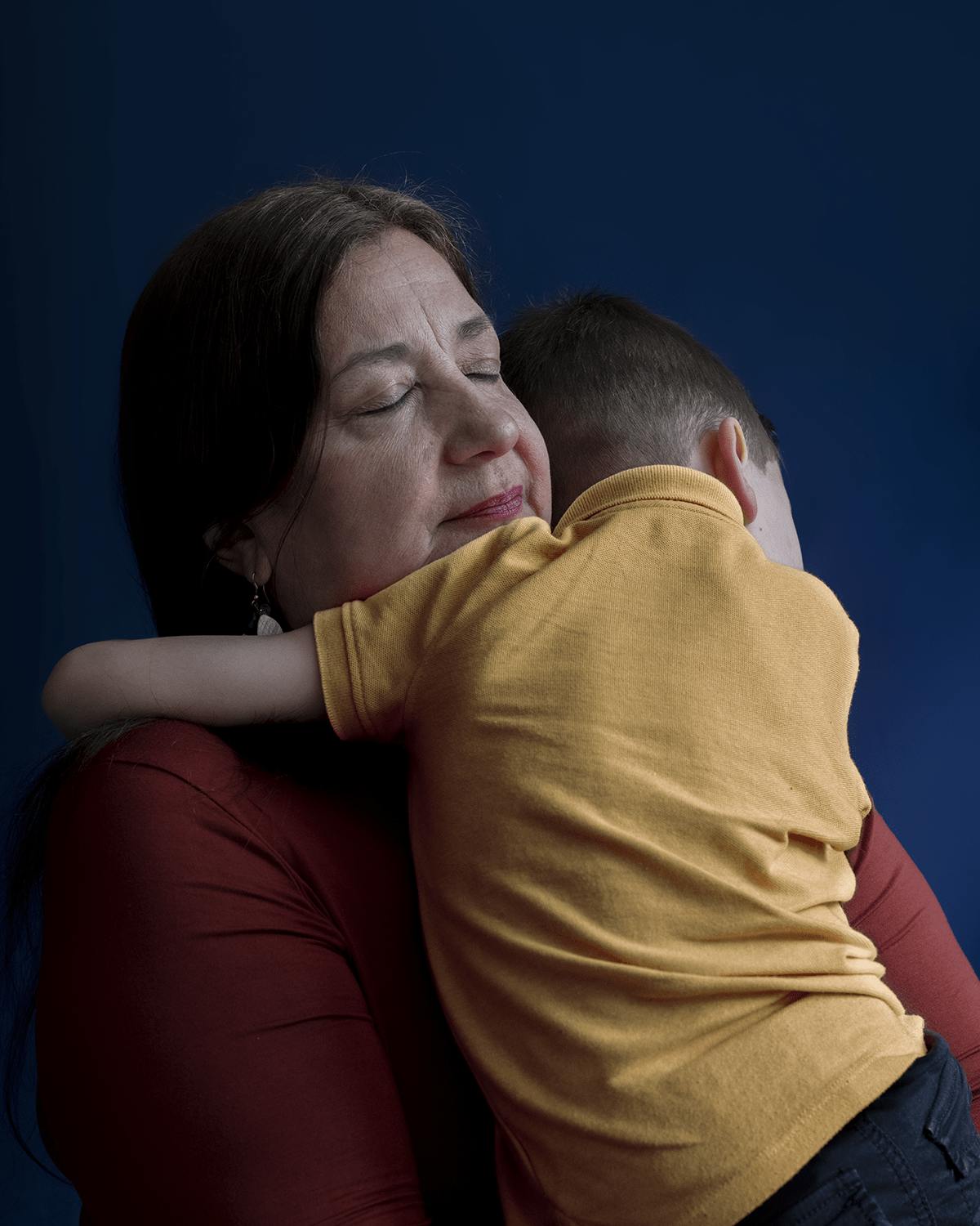 A close up portrait of Pilar hugging her grandson.