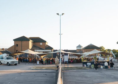 a wide angle shot of the car park, with the stage in the middle and a stretch tent with the audience underneath. The bar to the right and a coffee van on the left side
